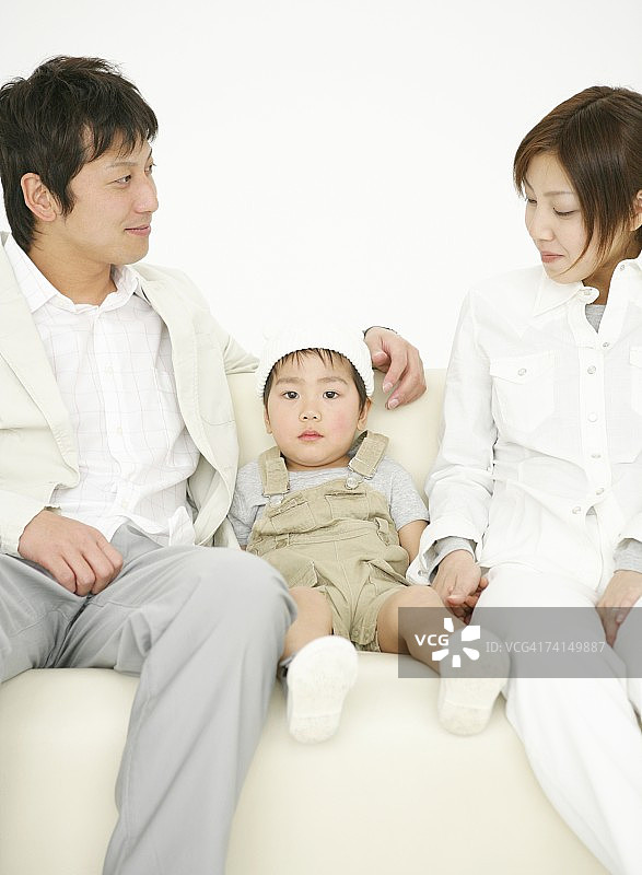 日本夫妇和男孩一起坐在沙发上图片素材