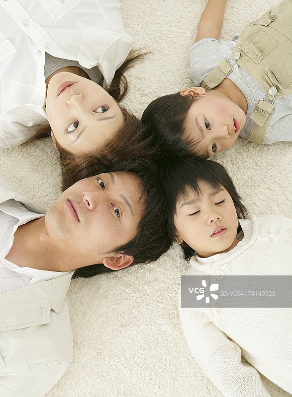日本夫妇和孩子躺在地板上图片素材