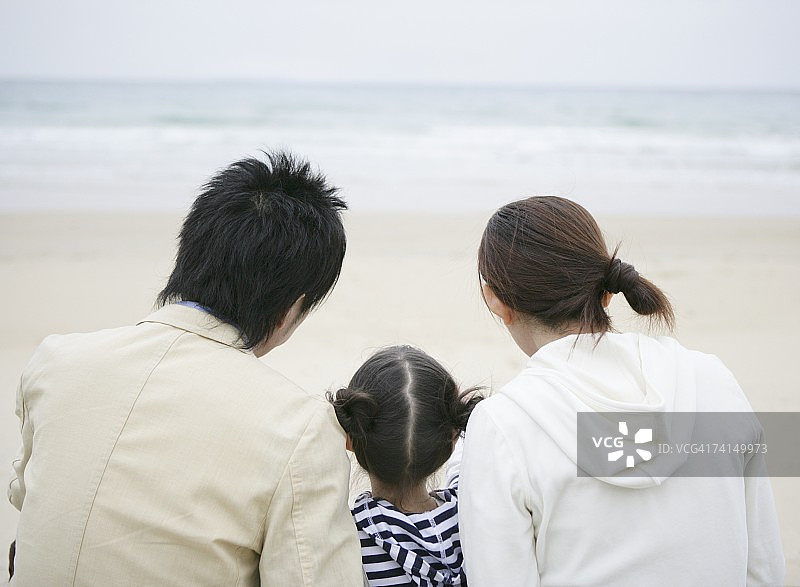 坐在海滩上的日本夫妇和女孩图片素材