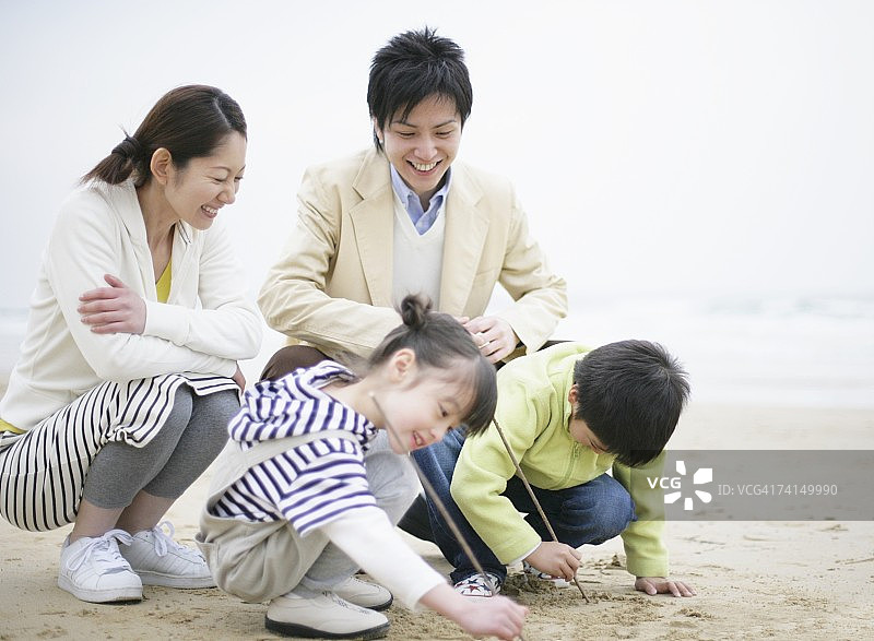 日本父母看孩子用树枝画画图片素材