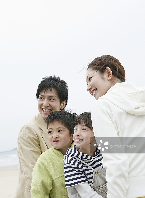 日本夫妇和两个孩子在沙滩上微笑图片素材