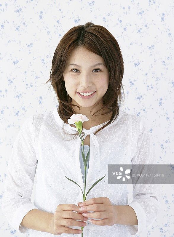 手持鲜花的日本女人，面带微笑图片素材