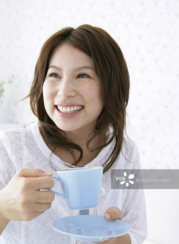日本女人拿着咖啡杯微笑图片素材