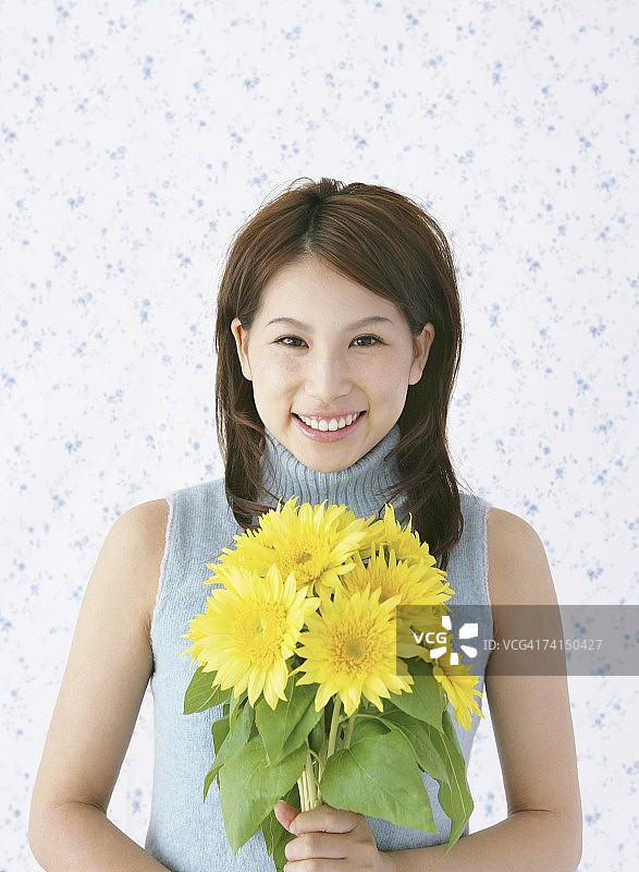 手持黄色鲜花微笑的日本女人图片素材