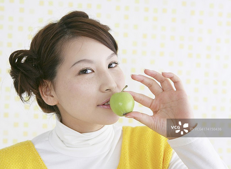 日本女人吃青苹果看向镜头图片素材