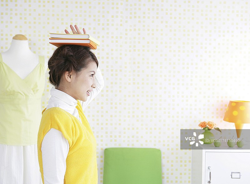 头顶着书行走的日本女人图片素材
