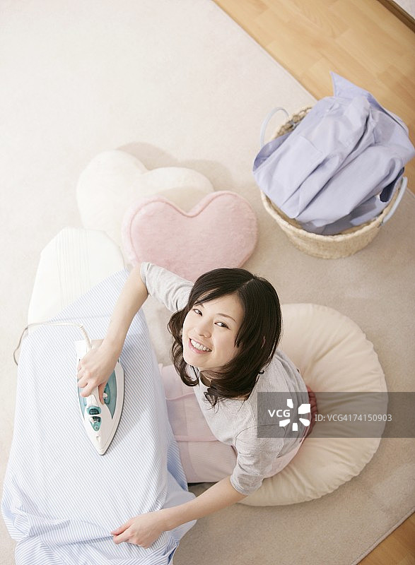 面带微笑的日本女人熨烫衣服图片素材