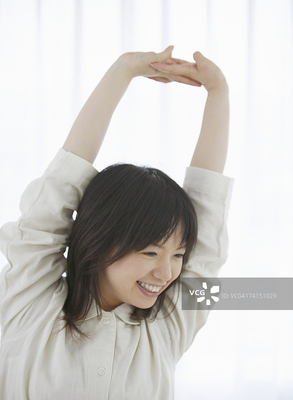 面带微笑做伸展运动的日本女人图片素材