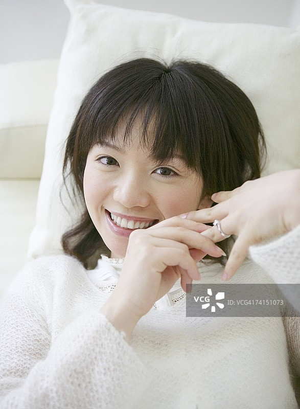 对着镜头微笑并触摸订婚戒指的日本女人图片素材