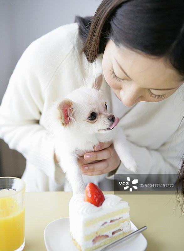 抱着乞讨的狗的日本女人图片素材