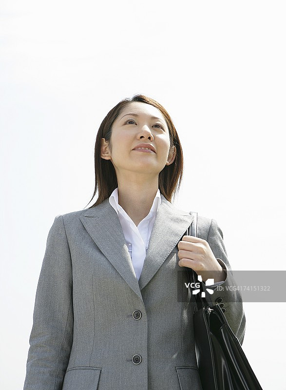 蓝天下微笑的干练女商人图片素材