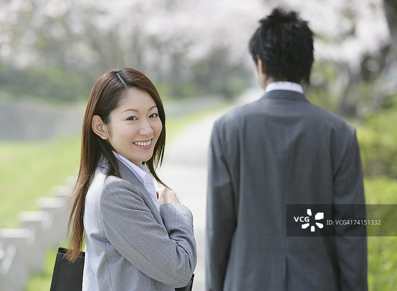 在樱桃树下微笑的商务情侣图片素材