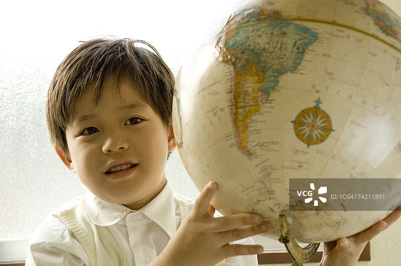 男孩手拿地球仪图片素材