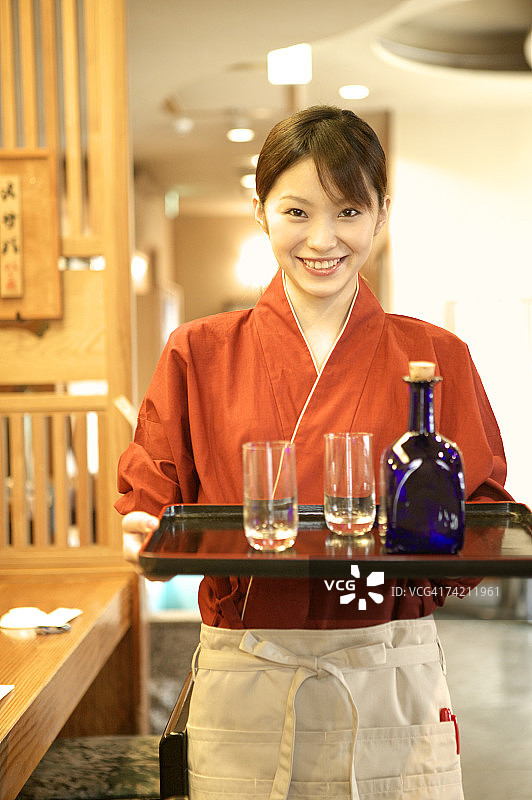 女服务员端着酒杯和瓶子托盘图片素材