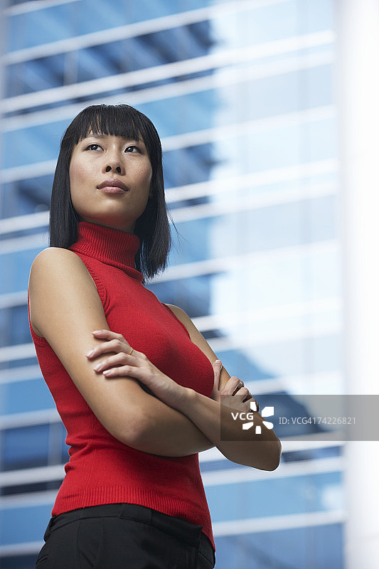 站在现代办公楼前的商务女性（低角度）图片素材