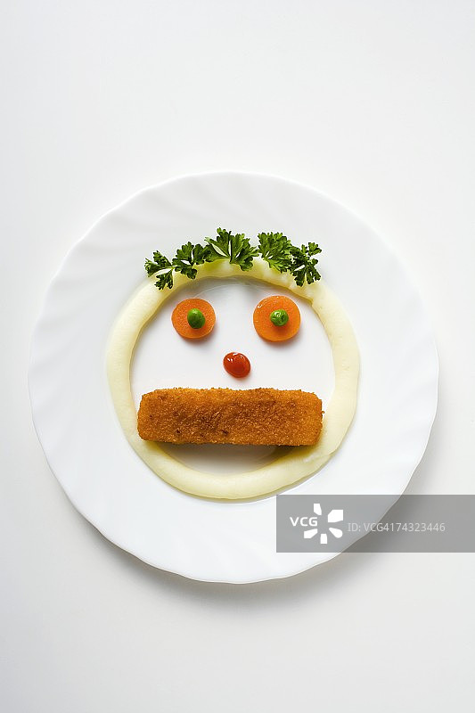 用鱼条、土豆泥和蔬菜做成的脸图片素材