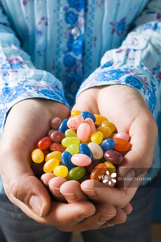 手捧彩色糖豆图片素材