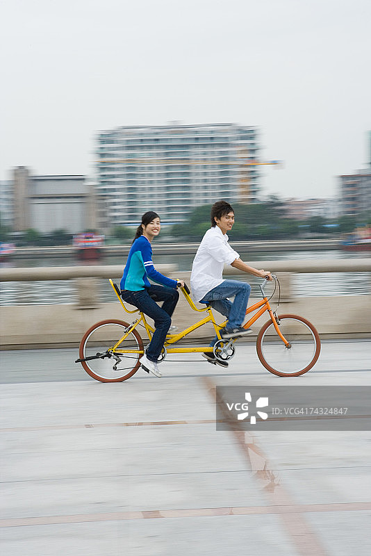 年轻夫妇骑双人自行车图片素材
