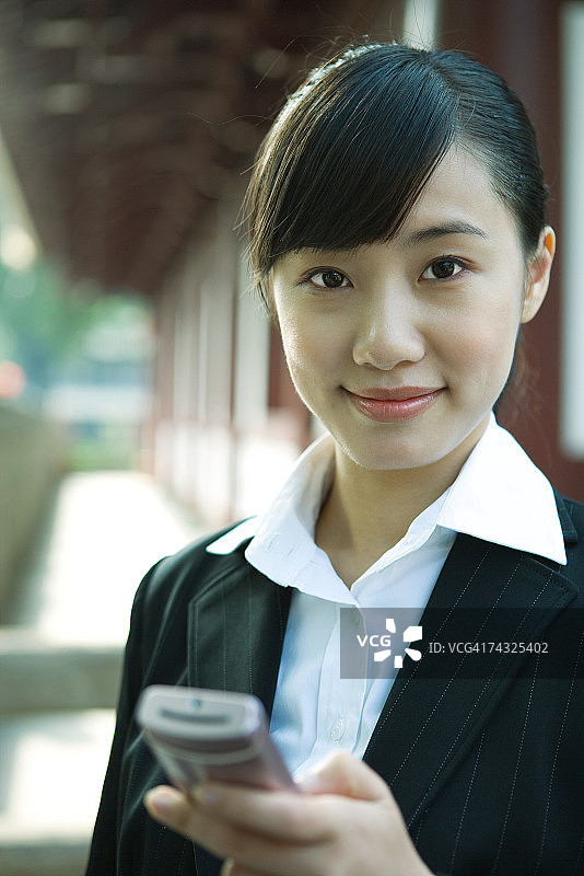 女人拿着手机对着镜头微笑图片素材