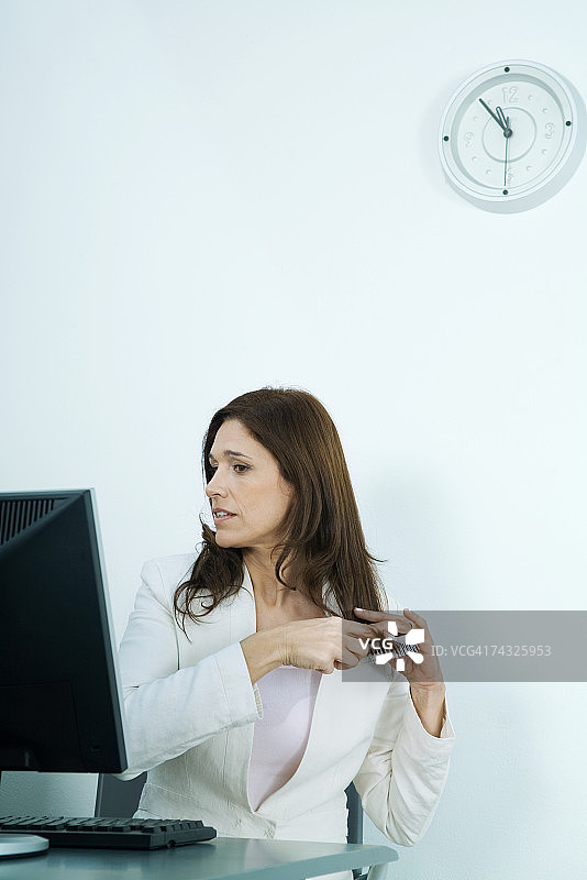 坐在电脑前梳头发的女商人图片素材