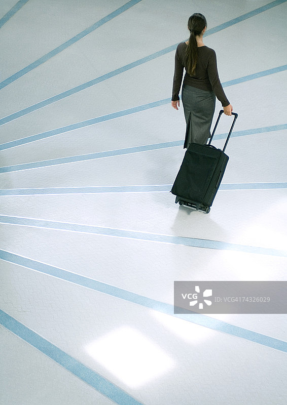 拉着行李箱的女人（高角度后视图）图片素材