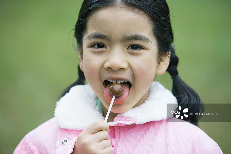 吃棒棒糖的女孩图片素材