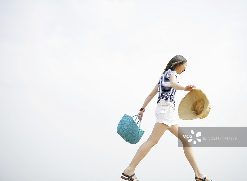 面带微笑步行的日本年轻女人图片素材