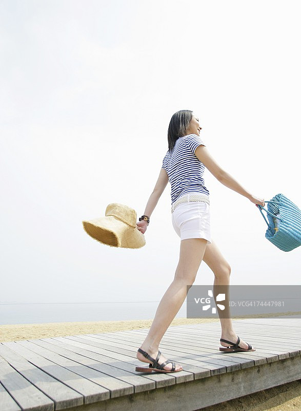 面带微笑步行的日本年轻女人图片素材