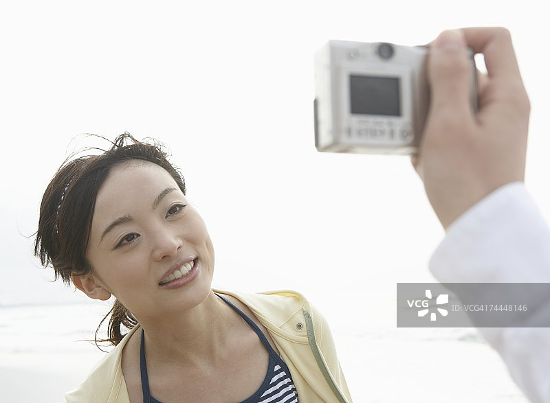 在海滩上为女人拍照的日本男人图片素材