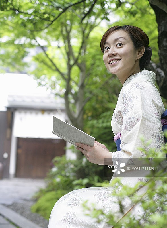 穿和服的日本女人在户外读书图片素材