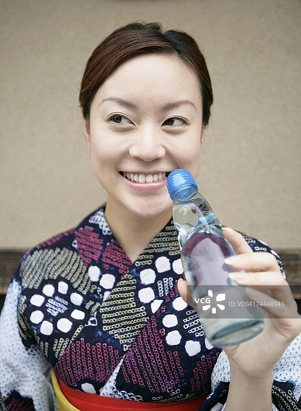 穿着和服的日本女人正在喝果汁图片素材