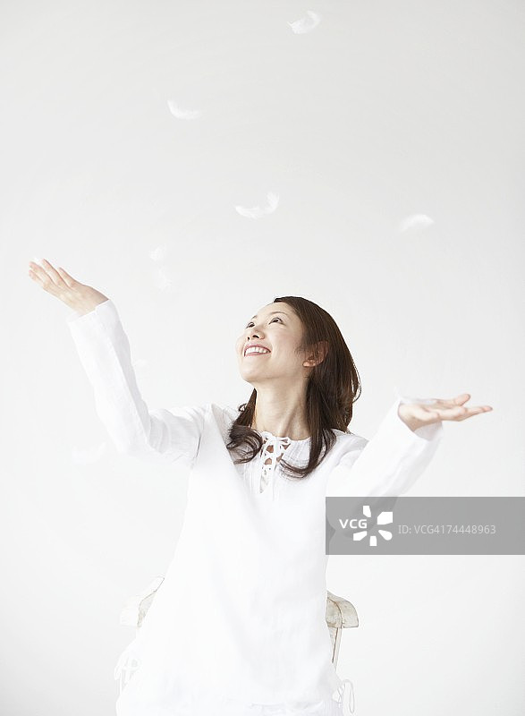 日本女人看着旋转的羽毛图片素材