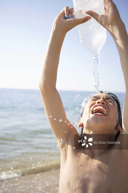 在海滩上洗脸的日本男孩图片素材