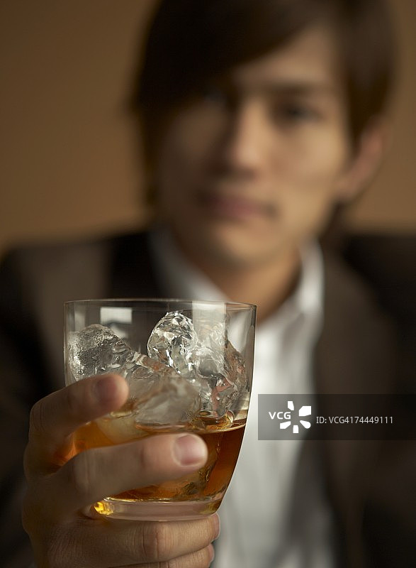 拿着一杯威士忌的日本男人的手图片素材