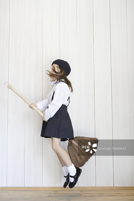 穿着校服骑着扫帚的美国女孩图片素材