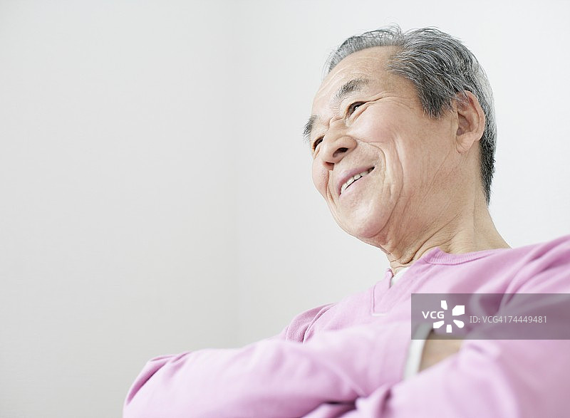 坐在沙发上微笑的日本成年男人图片素材