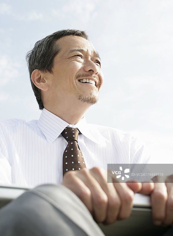 面带微笑眺望远方的日本成年男子图片素材