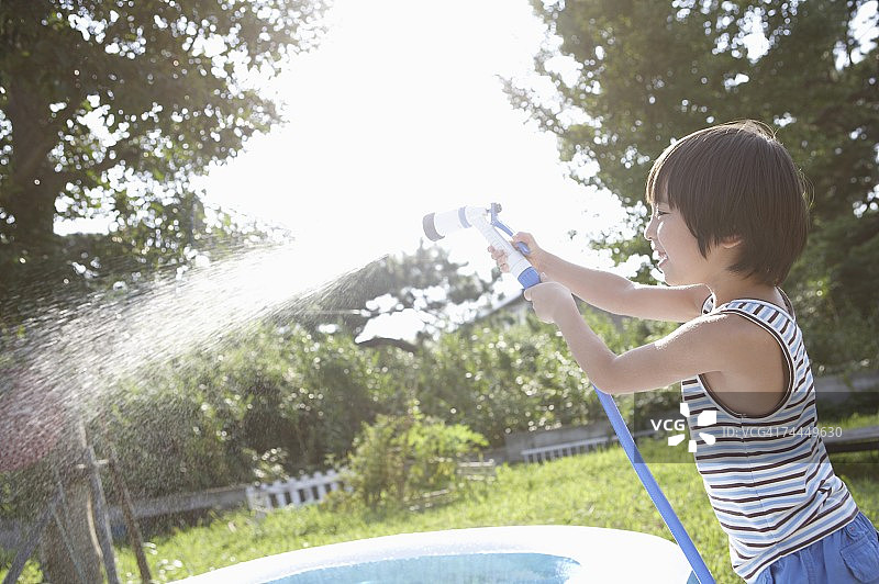 在花园里浇水的日本男孩图片素材