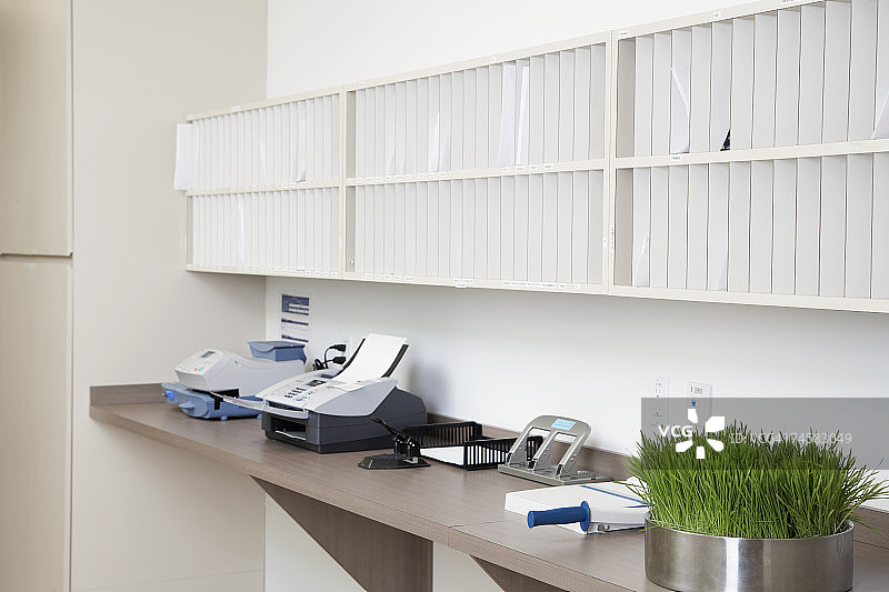 办公室邮件收发室，配有柜台、传真机、邮资计和邮件槽图片素材
