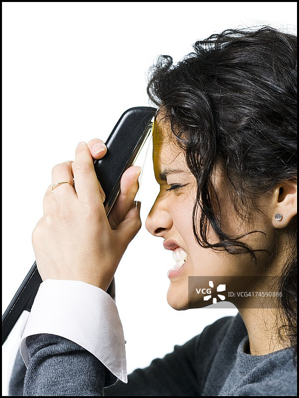 女人用订书机将便利贴贴在额头上图片素材