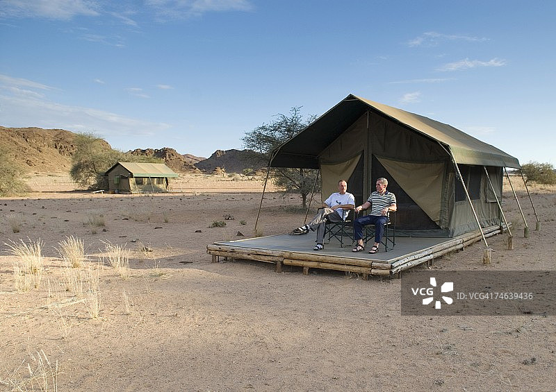 两名男子游客坐在旅行帐篷外图片素材