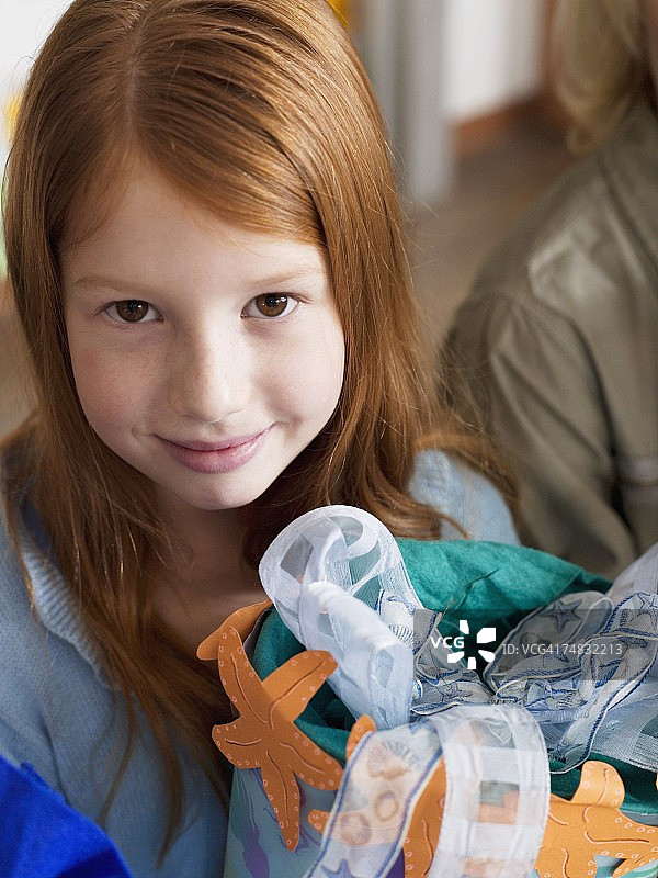 肖像：女孩（6-7岁）拿着开学礼物，高角度拍摄图片素材