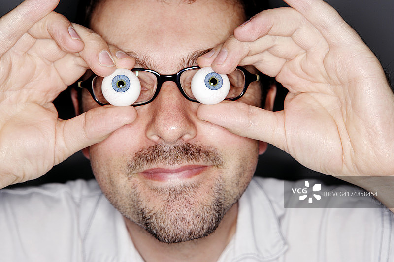 男人拿着玻璃眼球特写图片素材