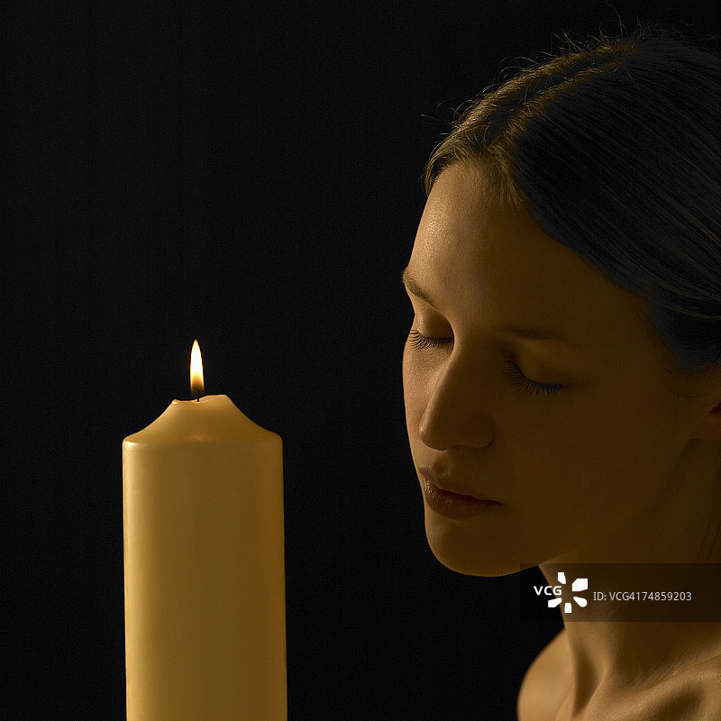 手持蜡烛的年轻女人图片素材