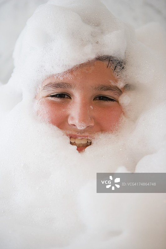 男孩在泡泡浴中微笑的肖像图片素材