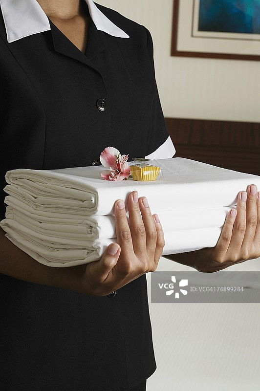 客房服务员搬运叠好的床单图片素材