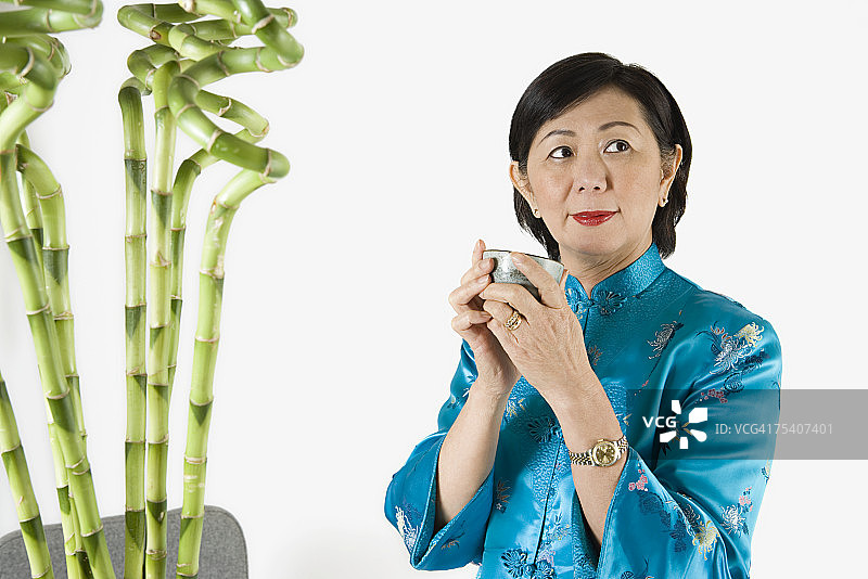 年长的女人拿着一杯茶图片素材