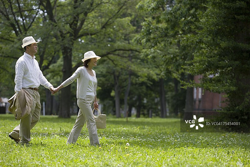 中年夫妇牵手行走图片素材