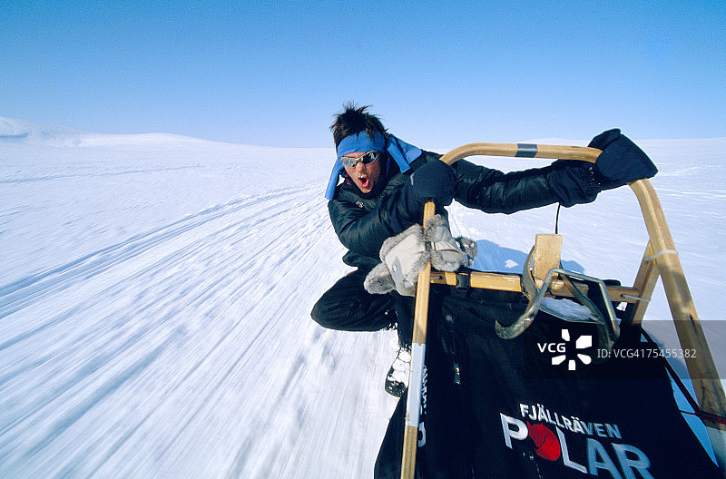 乘坐狗拉雪橇的男人图片素材