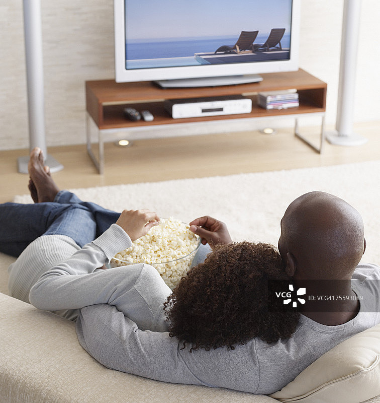 一对情侣看电视吃爆米花图片素材